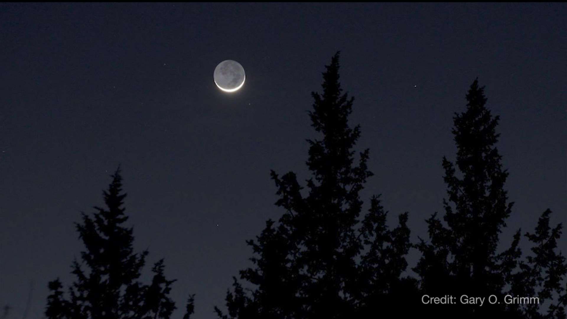 Earthshine is visible on the unlit part of the crescent moon