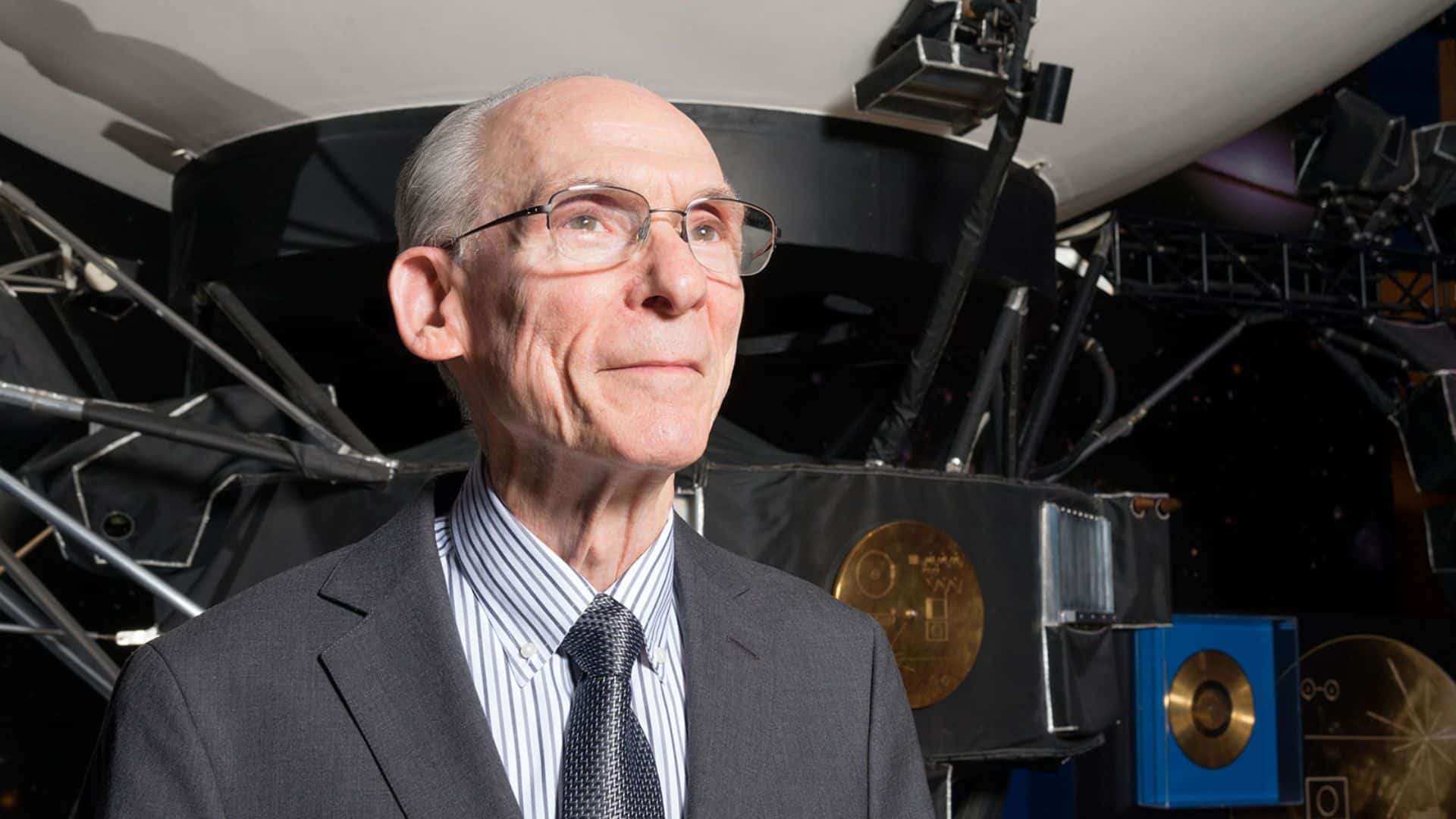 Ed Stone stands in front of a full-size model of the Voyager spacecraft at NASA's Jet Propulsion Laboratory (JPL) in 2019